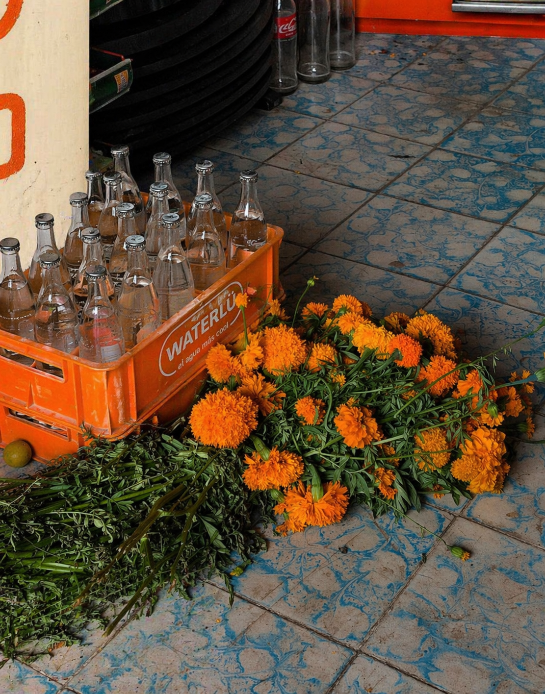 Caja WATERLÜ naranja con cempasúchil en el mercado